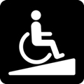 Ramp. The icon shows a person in a wheelchair proceeding up a low, triangular inclined surface, against a dark background.