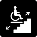 Stairlift. The icon shows a person sitting in a wheelchair on top of a platform. The platform is above a staircase. On the left of the platform is an arrow pointing down to the left, and on the right is an arrow pointing up to the right.