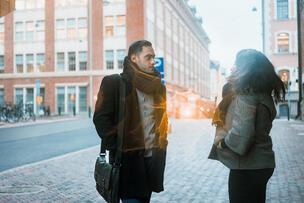 Kaksi ihmistä keskustelee kadulla.