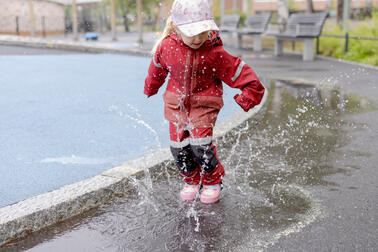 A child playing in a puddle.