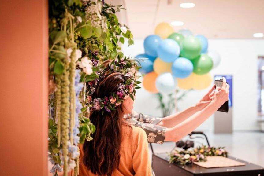 Kaksi kukkakruunuista naista ottaa selfie-kuvaa itsestään.