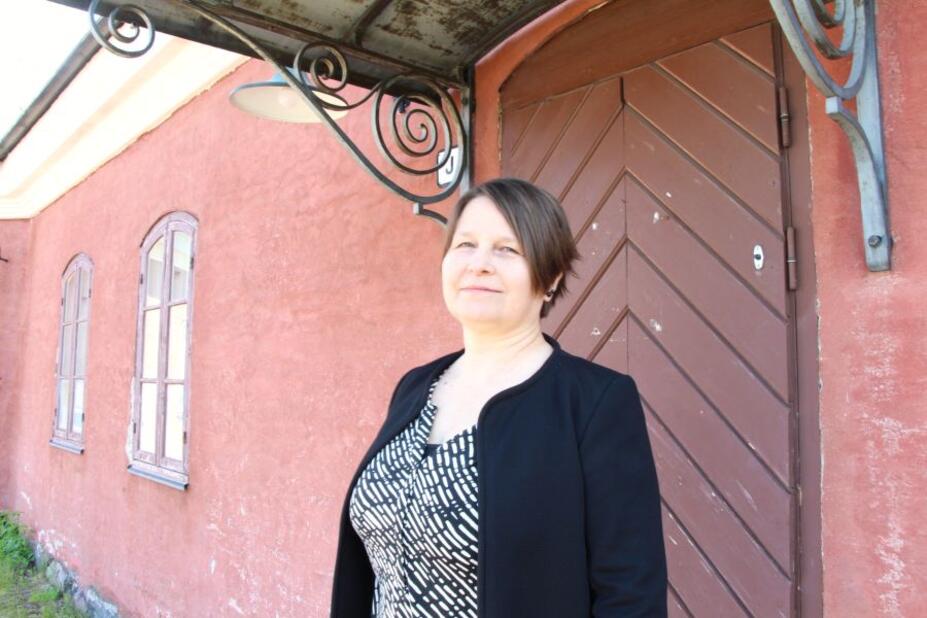 Päiväkodin johtaja Maritta Mellin hymyilee päiväkodin edessä.