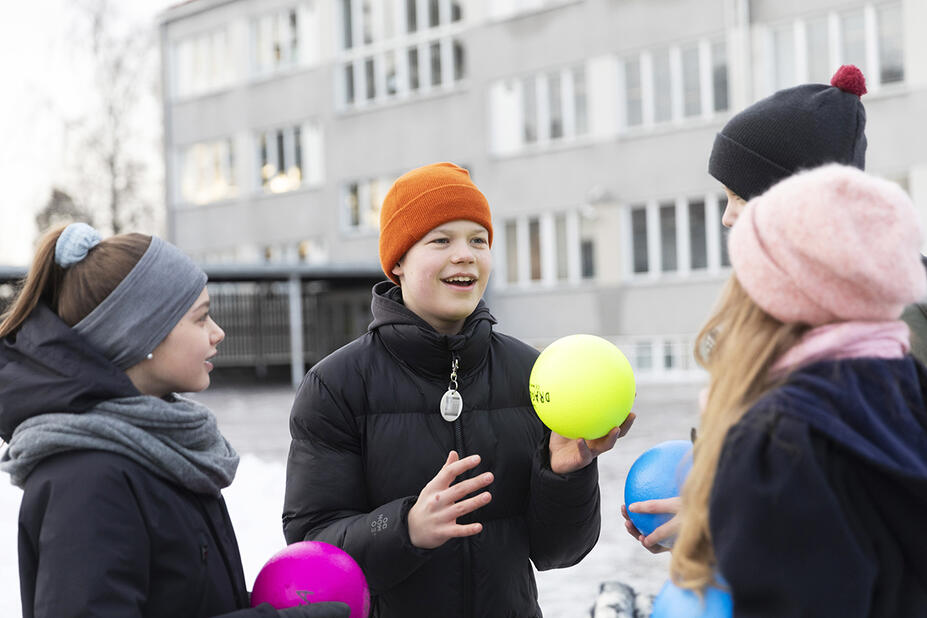 Tukioppilaita koulun pihalla pallojen kanssa