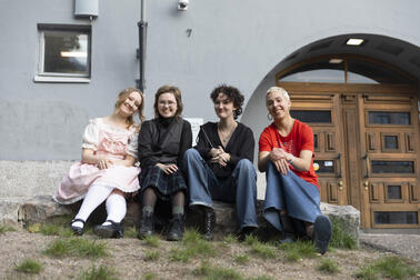 Lukiolaisia istumassa nurmikolla.