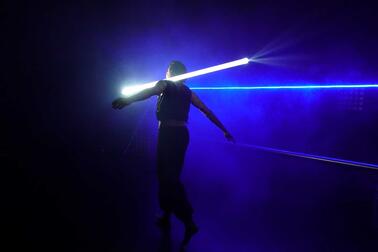 Mies ja valoseiväs tummalla taustalla.