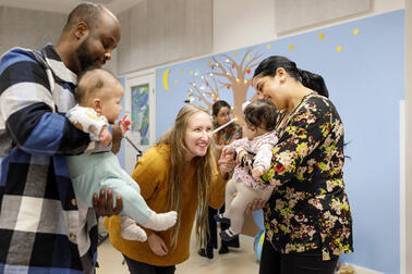 Two small children are enjoying a music event with their parents.