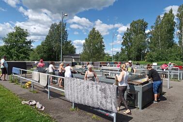 Ihmisiä pesemässä mattoja.