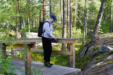 Korkeakouluharjoittelija Essi Kaila kokoamassa esteettömyystietoja luontopolulla.