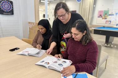 opettaja auttaa KOTIVA-tunnilla opiskelijaa tehtävän tekemisessä..