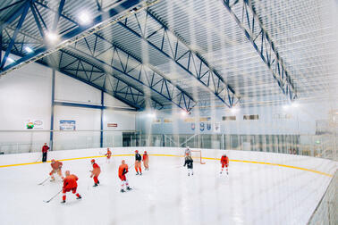 Rödklädda spelare på en hockeymatch i en ishall.