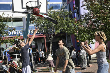 Kolme ihmistä pelaa koripalloa Kontulan ostarilla.