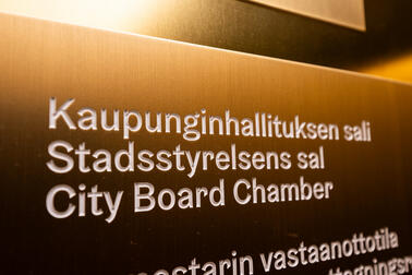 Kuvituskuva kaupunginhallituksen istuntosalin kyltistä.