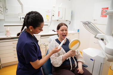 Työntekijä ja asiakas hammashoitolassa.