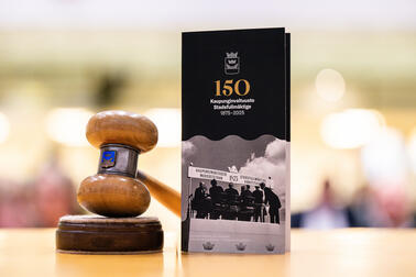 Valtuuston puheenjohtajan nuija sekä juhlavuoden esite pöydällä