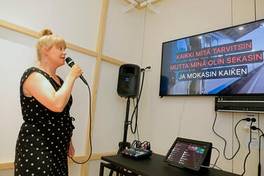 Nainen laulaa karaokea.