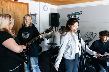 Fyra unga har samlats för att träna i ett band.