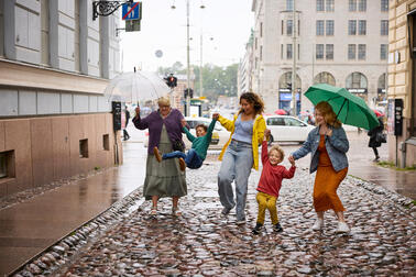 Perhe sateisella kadulla.