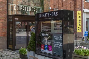 Kulttuurikeskus Caisan sisäänkäynti: punatiilisessä talossa valokyltti "Leipätehdas", mainosvitriini ja keltainen banderolli, jossa lukee Caisa.