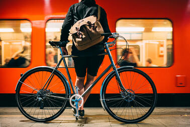 Matkustaja odottaa laiturille saapuneeseen metroon nousemista polkupyöränsä kanssa.