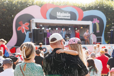 Mies, nainen ja lapsi katsomassa bändiä malmin tapahtumakesässä