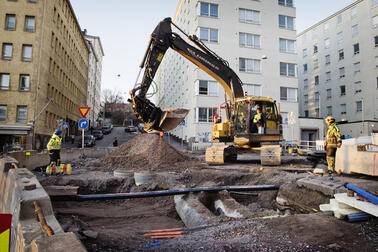 Kaivuri ja työmaahenkilöstöä Hämeentien katutyömaalla.