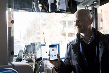Matkustaja näyttää bussissa kuljettajalle lippua.