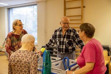 Neljä henkilöä liikuntasalissa.