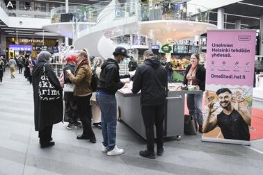 Ihmiset keskustelevat OmaStadin äänestyksestä Triplan kauppakeskuksessa.