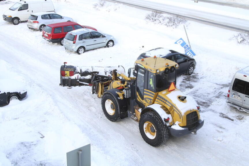 Aura-auto auraa henkilöautojen keskellä. Aura-auto auraa henkilöautojen keskellä.