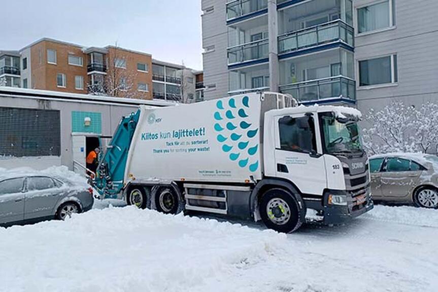 Jäteauto lumisella kerrostalopihalla. Jäteauto lumisella kerrostalopihalla.