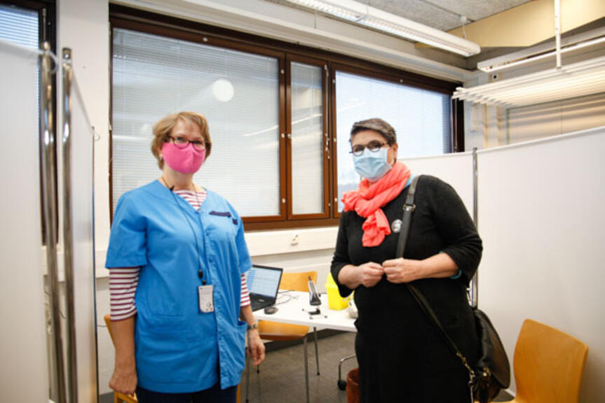 Hoitaja ja asiakas rokotuspisteellä. Hoitaja ja asiakas rokotuspisteellä.