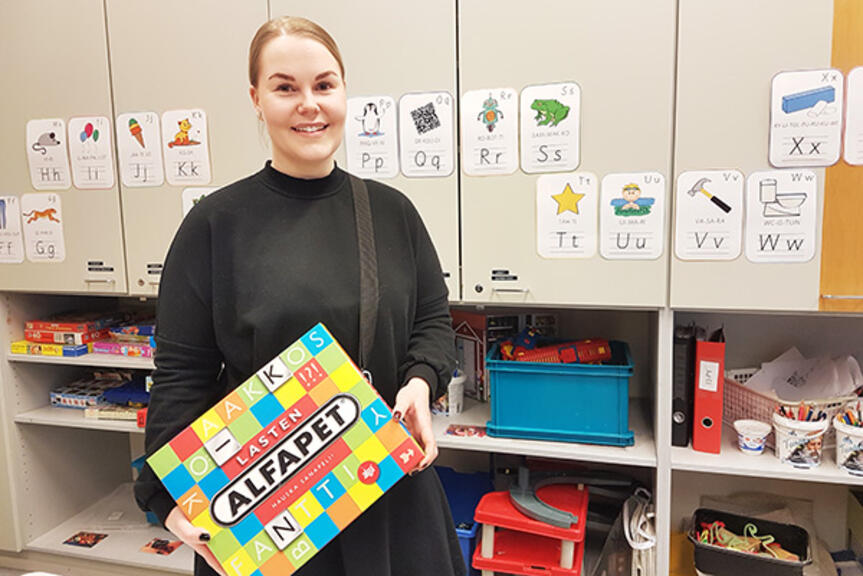 Tinka Ripatti eskarin tilassa sanapeli käsissään. Tinka Ripatti eskarin tilassa sanapeli käsissään.