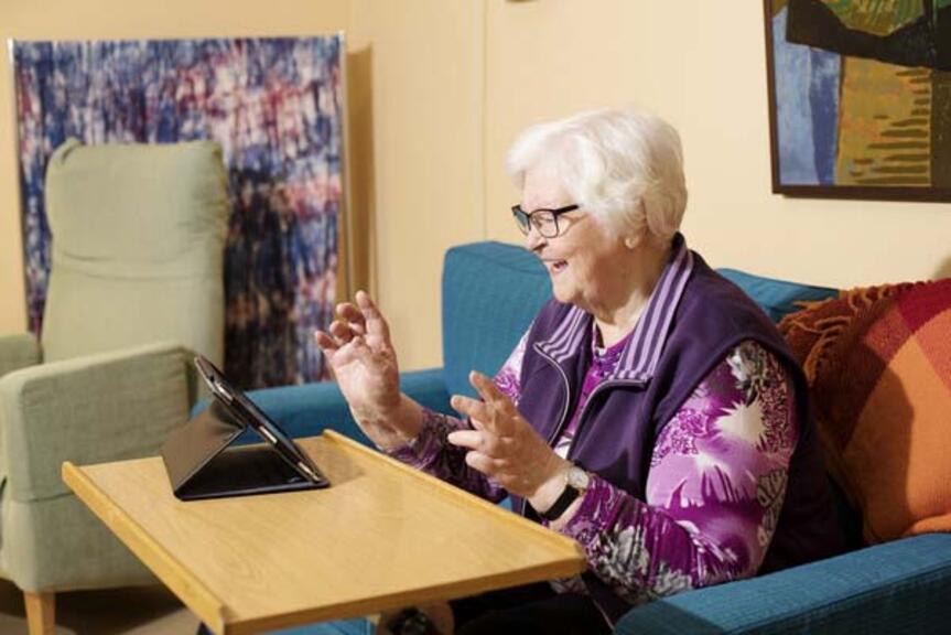 Vanhempi henkilö katselee ohjelmaa tabletilta.
