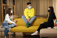 Kolme nuorta istuu sohvalla keskustelemassa maskit kasvoillaan nuorisotalolla