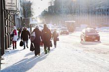Jalankulkijoita ja autoliikennettä talvisessa kaupungissa.