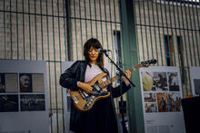 Nainen soittaa kitaraa kulttuuritapahtumassa.