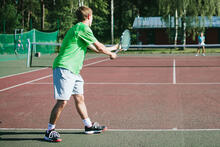 Kuvassa tenniskenttä ja -pelaajia.