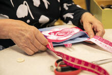Ruusukuvioinen kangaslaukku valmistumassa käsityönä.