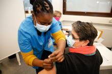 Terveydenhoitaja antamassa rokotusta rokotettavalle.