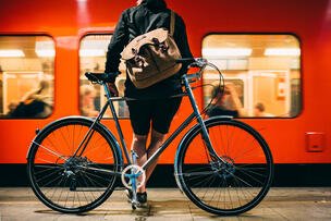 Matkustaja odottaa laiturille saapuneeseen metroon nousemista polkupyöränsä kanssa.