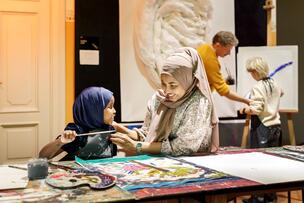 Lapsia maalaamassa pöydän ääressä.