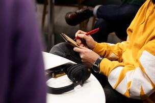 Henkilö kirjoittaa muistiinpanoja