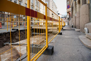 Työmaa-aitaa, jonka takana näkyy avoin kaivanto.