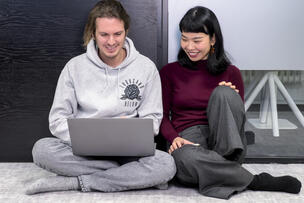 kaksi henkilöä katsomassa kannettavan tietokoneen näyttöä