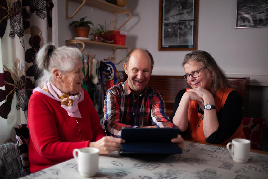 Ihmisiä tablet-laitteen äärellä.