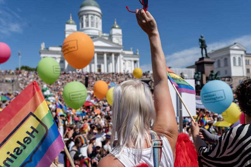 Ihmisiä on kokoontunut Senaatintorille sateenkaarilippujen kanssa