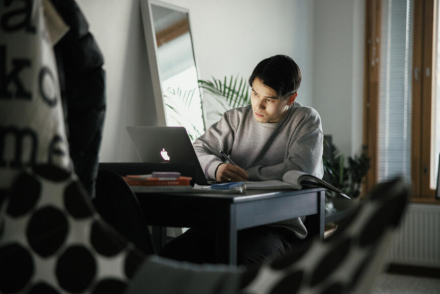 Nuori mies työskentelee tietokoneella