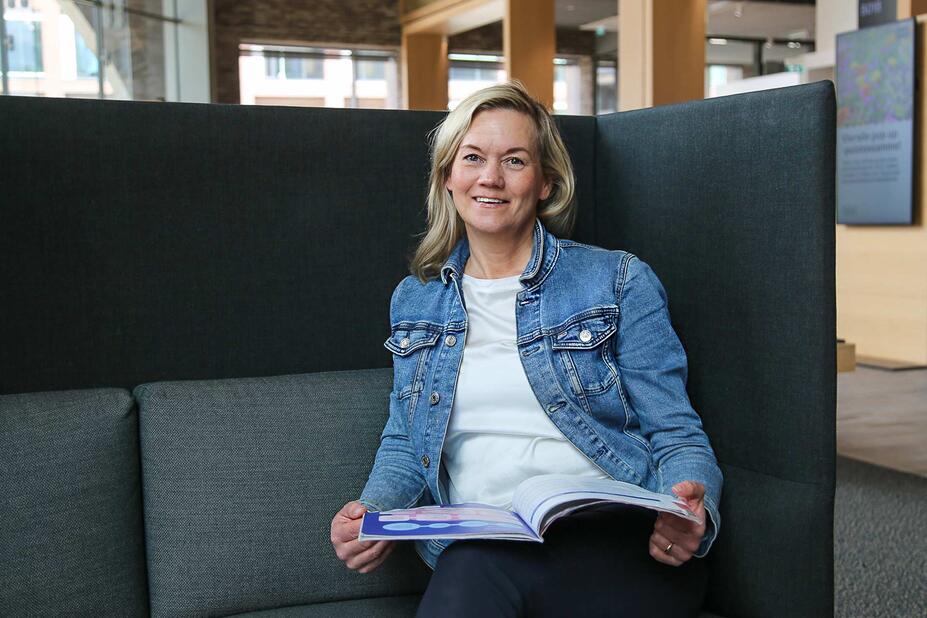 Kati Immeli-Vänskä istuu nojatuolilla toimistolla.