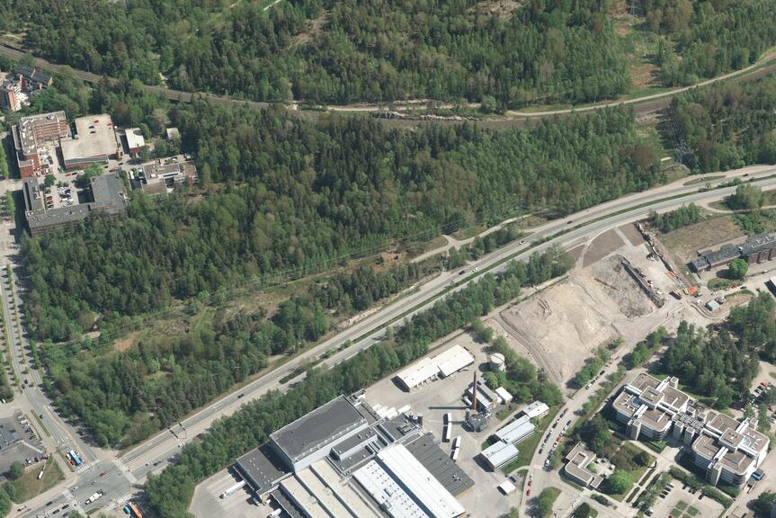 Ilmakuva alueesta, jossa on metsää ja rakennuksia.