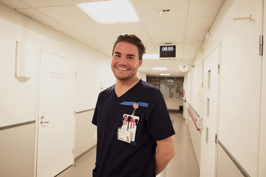 Antti Laitinen seisoo Laakson sairaalan osaston käytävällä ja hymyilee kameralle.